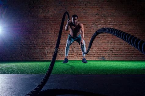 Two Multiethnic Bare Chest Sportsmen Exercising With Battle Ropes At