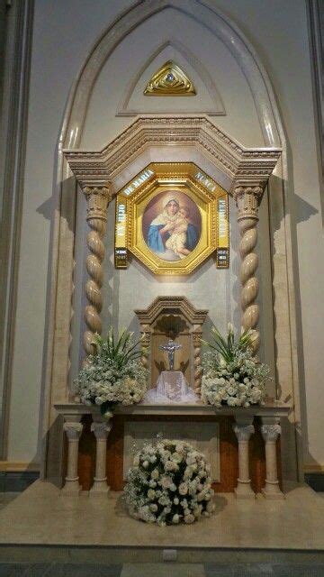 The Altar Is Decorated With White Flowers And Greenery