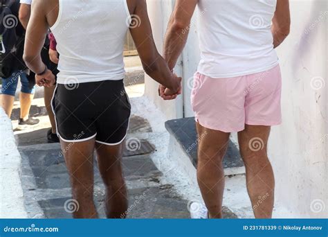 Pareja Gay Cogiendo La Mano Y Caminando Al Aire Libre Mykonos Greece Imagen De Archivo