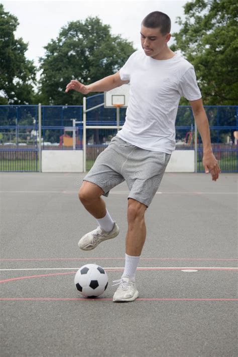 A 19 Year Old Teenage Boy Playing Football In A Public Park Stock Photo