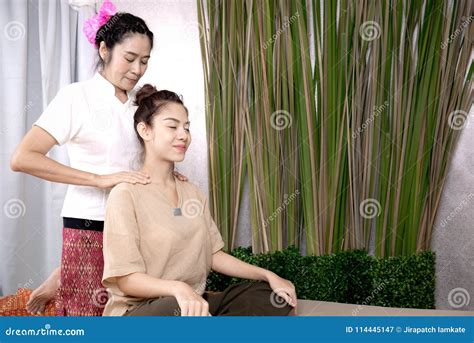 Professional Therapist Giving Traditional Thai Massage To A Woman In