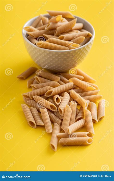 Uncooked Whole Grain Pasta Raw Penne Pasta On Yellow Background Stock