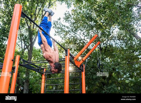 Athletic young man doing skin the cat exercise during advanced workout ...