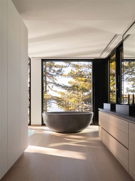 A Large Bathtub Sitting In The Middle Of A Bathroom Next To Two Sinks