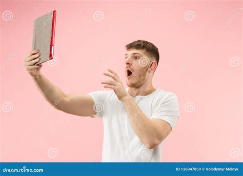 Portrait Of Smiling Man Pointing At Laptop With Blank Screen Isolated