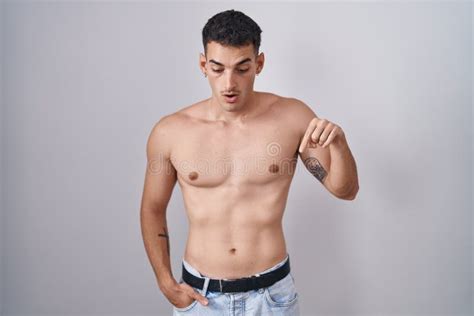 Handsome Hispanic Man Standing Shirtless Pointing Down With Fingers