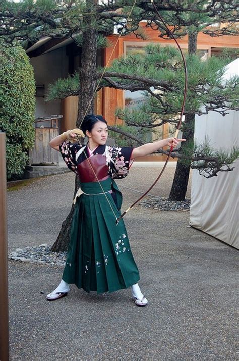 Japanese archer wearing traditional Hakama, with her yumi and archer's ...