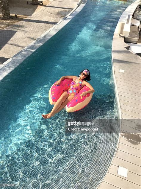 Woman Lying In Doughnut Inflatable Rubber Ring In Swimming Pool High