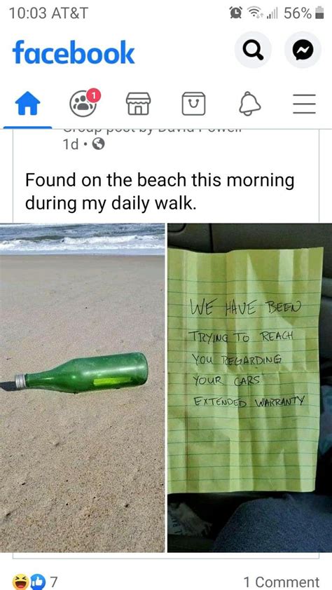 A Green Bottle Sitting On Top Of A Sandy Beach Next To A Sign That