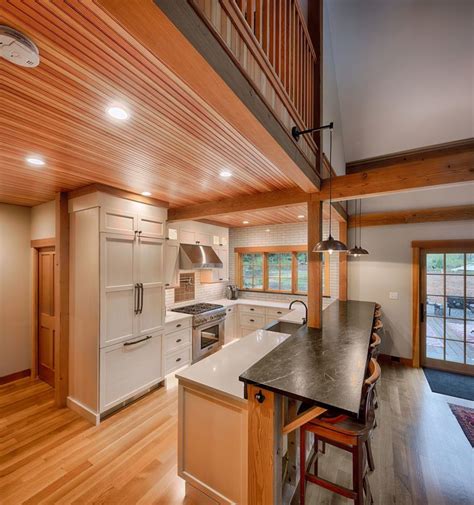 A Kitchen With An Island And Wooden Floors In The Middle Along With