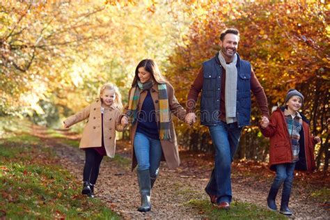 Familia Con Padres Maduros Y Dos Hijos Tomados De La Mano Caminando Por