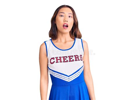 Young Beautiful Chinese Girl Wearing Cheerleader Uniform In Shock Face