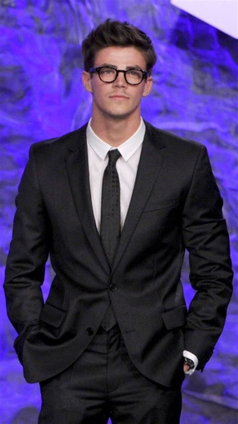 A Man In A Suit And Tie Standing Next To A Purple Wall With Blue Lights