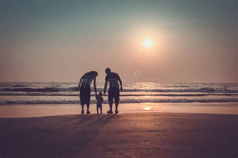 Schattenbild Der Familie Auf Dem Strand Am Sonnenuntergang Stockfoto