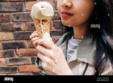 Woman Holding Melting Ice Cream In Front Of Wall Stock Photo Alamy