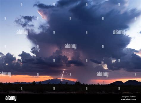 A Thunderstorm Lightning Bolt Hitting A Mountain At Sunset In Arizona