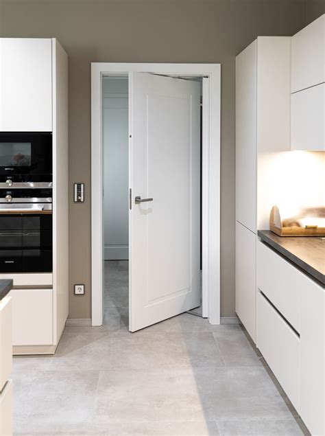 A Kitchen With White Cabinets And An Open Door