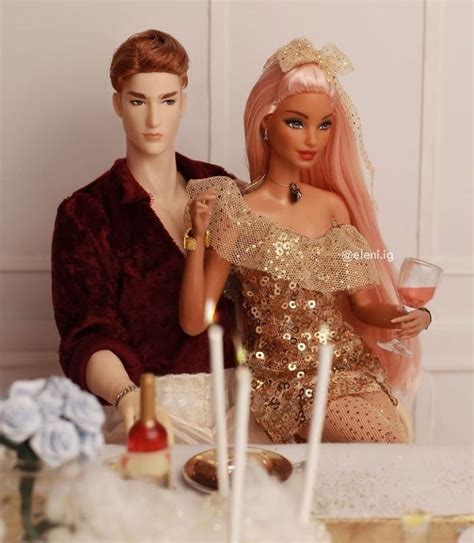 Two Barbie Dolls Sitting Next To Each Other At A Table With Candles In