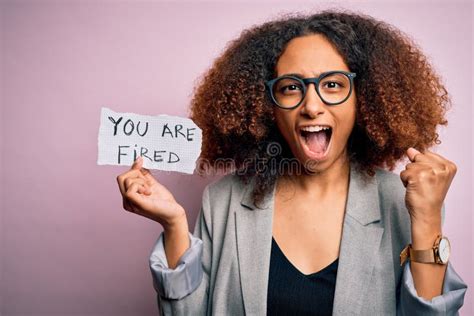 Young African American Woman With Afro Hair Holding Paper With You Are Fired Message Screaming