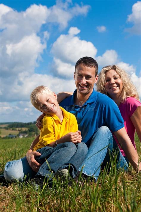 Famille S Asseyant Devant Leur Maison Photo Stock Image Du Bleu