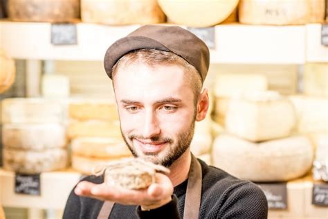 Retrato De Un Guapo Vendedor De Queso En Uniforme Sosteniendo Queso De