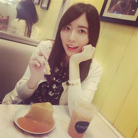 A Woman Sitting At A Table With A Plate Of Food And Drink In Front Of Her