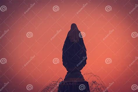 Silhouettes Of The Blessed Virgin Mary Statue Figure In A Warm Tone Sunset Scene Catholic