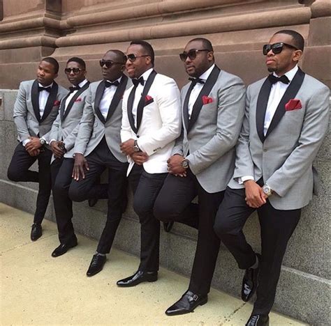 A Group Of Men In Suits And Sunglasses Sitting Next To Each Other Near