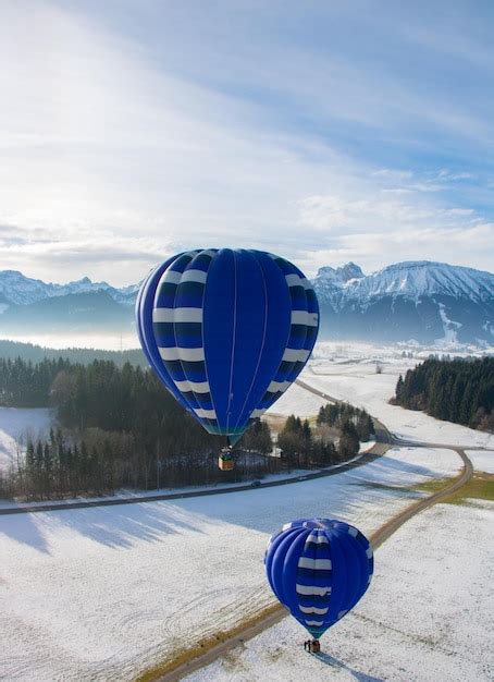 Hot Air Balloon Over Snow Covered Landscape Premium Photo