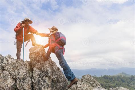 Team Of Climbers Man And Woman Help Each Other On Top Of Mountain