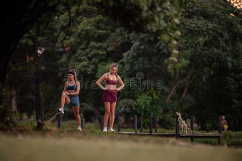 Fit Girls Exercising And Warming Up Outdoors In A Green Park Athletic