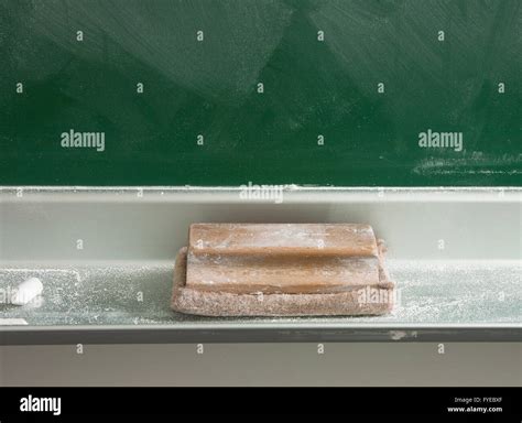 Detail Of An Eraser Placed Beside A Chalkboard And A Little Chalk Full