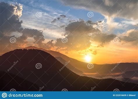 Sunset Landscape Of High Mountain Peaks And Foggy Valley Under Vibrant