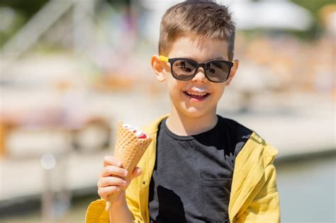 Premium Photo Happy Little Boy Eats Ice Cream In A Waffle Cone In