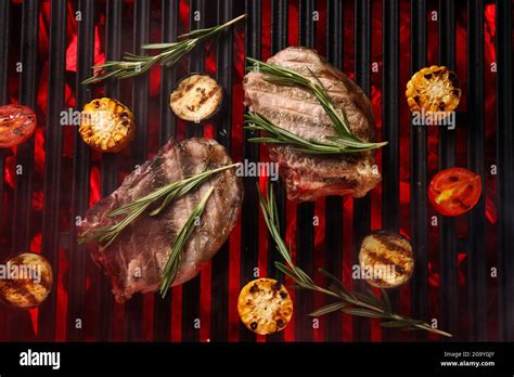 Tasty Steaks With Rosemary And Vegetables On Barbecue Grill Stock Photo