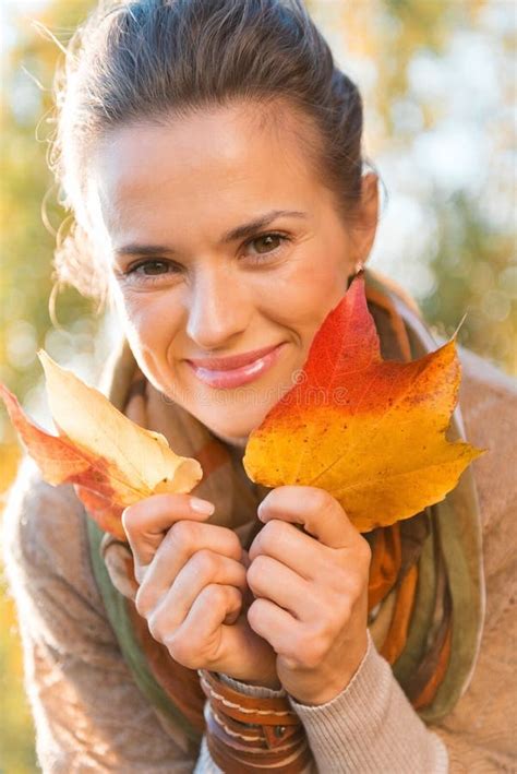 El Retrato De La Mujer Relajada Sonriente Con Otoño Hojea Imagen de