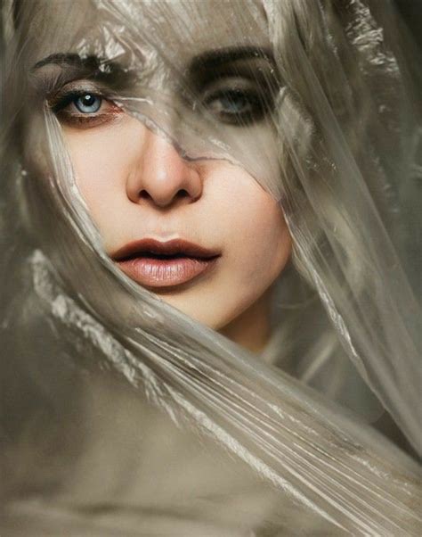 A Woman With Long White Hair And Makeup Is Wrapped In Plastic Wraps To