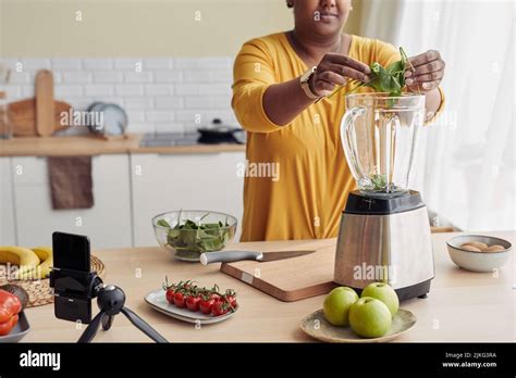 Cropped Shot Of Black Woman Putting Spinach In Blender While Making