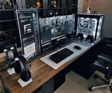 Two Computer Monitors Sitting On Top Of A Wooden Desk Next To A