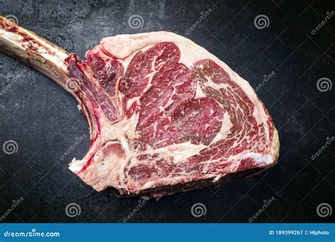 Traditional Raw Dry Aged Wagyu Tomahawk Steak On An Old Rustic Board