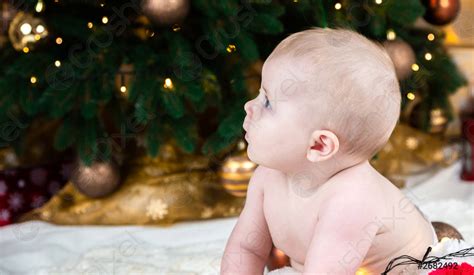 Naakte Baby Op De Vloer In De Gedecoreerde Kerst Kamer Stockfoto