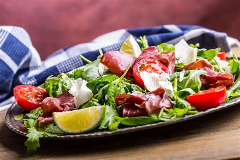 Dried beef bresaola. Salad bresaola arugula baby spinach tomatoes lime ...