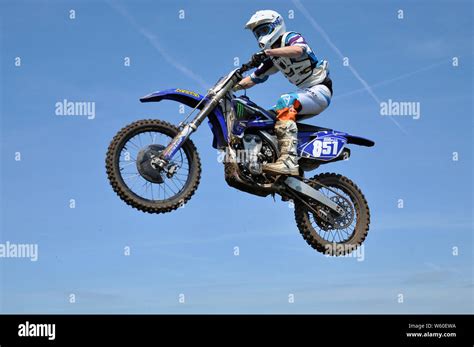 Motorbike Rider On Scramble Bike Jumping High In Blue Sky Motocross