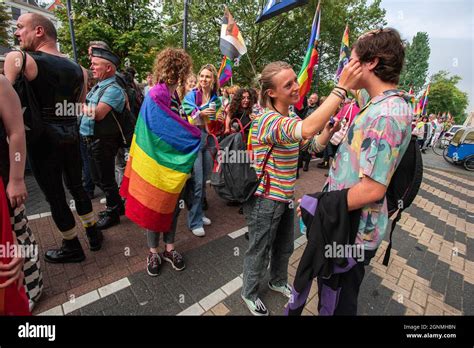 A Female Demonstrator With Make Up Puts Glitter On A Mans Face