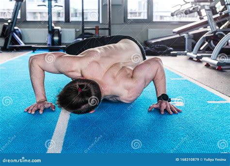 A Naked Torso Man In The Gym Does Push Ups Touching The Floor With His