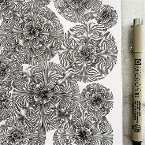 A Pen Is Sitting On Top Of A Drawing Paper With An Image Of Flowers In