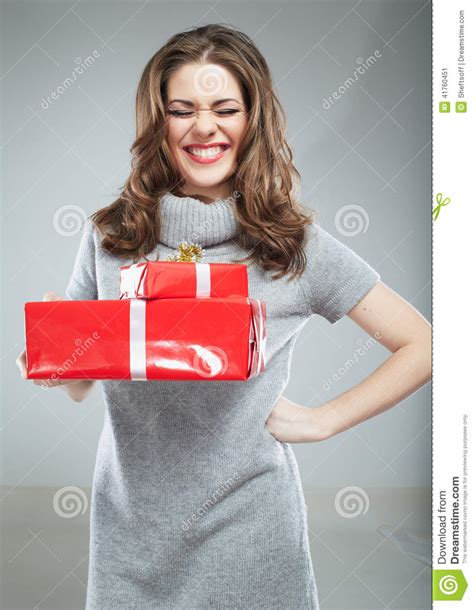 Asimiento De La Mujer De La Caja De Regalo Contra Fondo Gris Imagen De