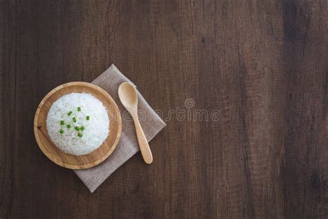 Cooked White Rice In A Wooden Dish With Green Onion Sliced On Top With