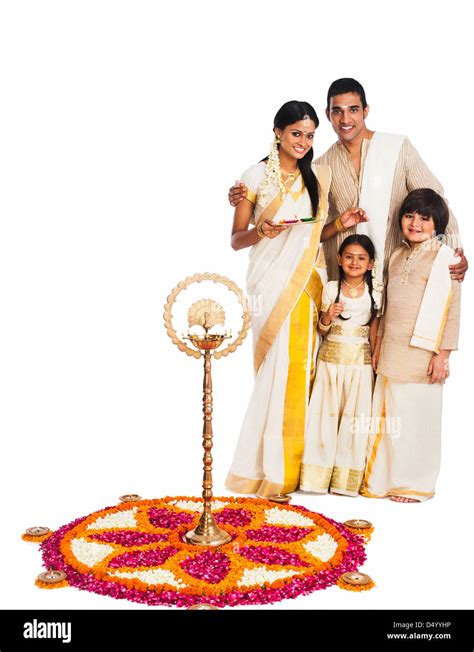 South Indian family standing near rangoli of flowers at Onam Stock ...