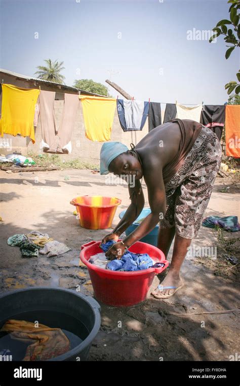 Afrikanerin waschen und Aufhängen der Kleidung hinter ihrem Haus Tanji